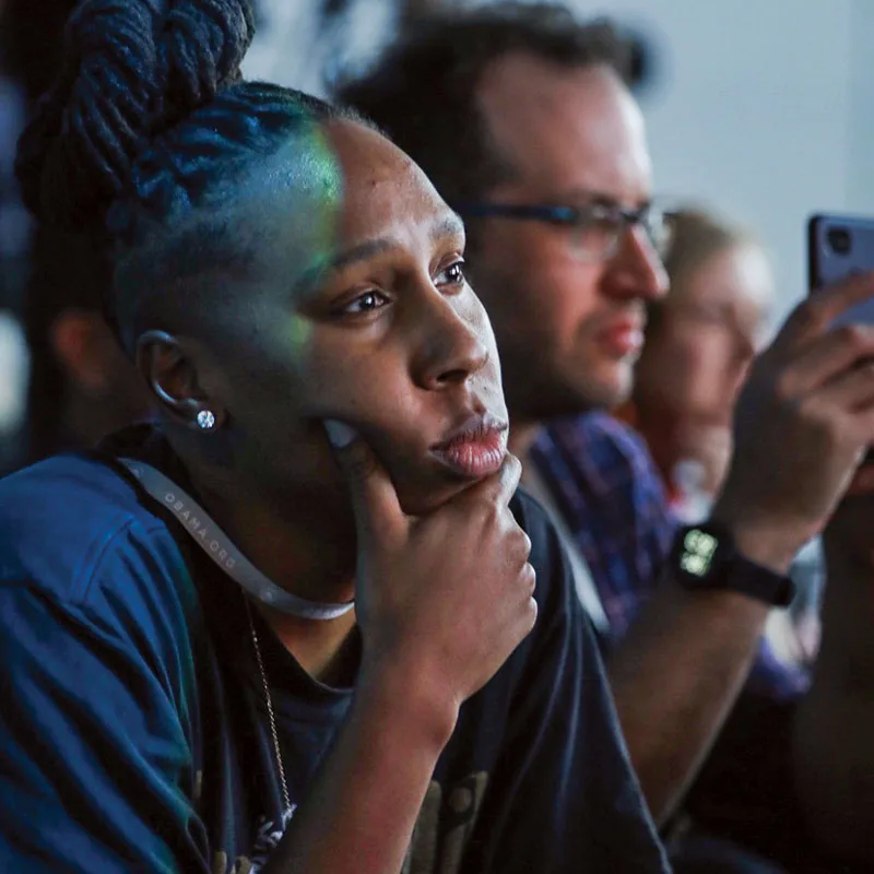 Lena Waithe sits with her hand on her chin while listening to remarks during the Obama Foundation Summit.
