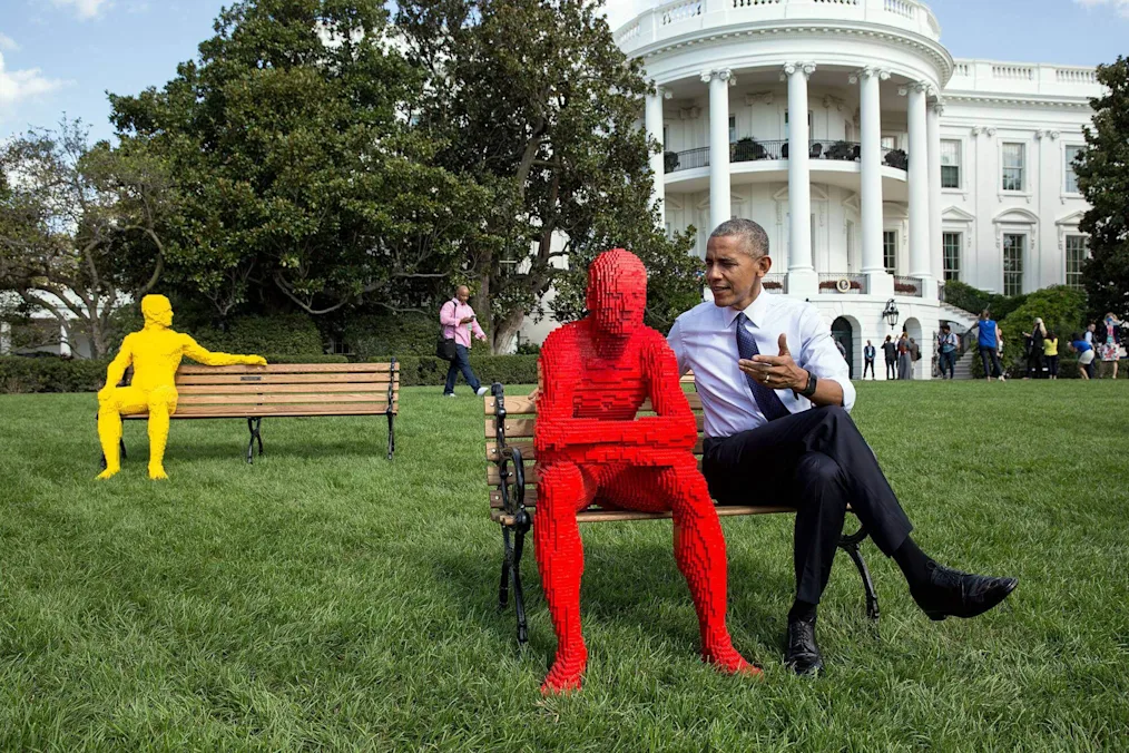 President Barack Obama sits with a Lego statue