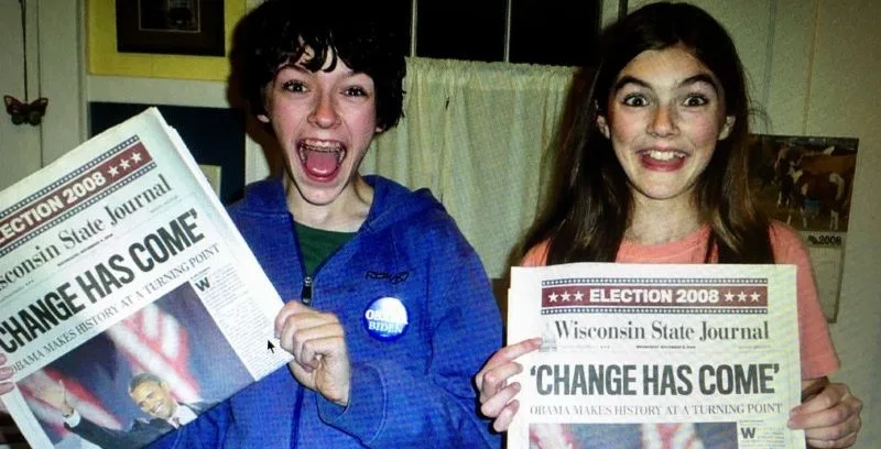 Two people holder "Obama has won!" newspaper
