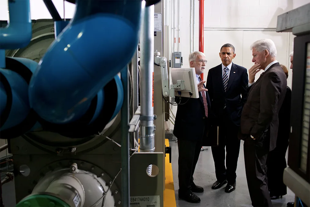 President Barack Obama and former President Bill Clinton listen