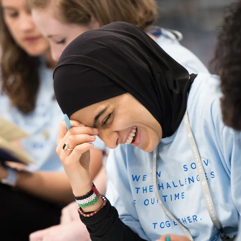 A young woman looks down laughing at an Obama Foundation Community Leadership Corps kickoff event in 2018.