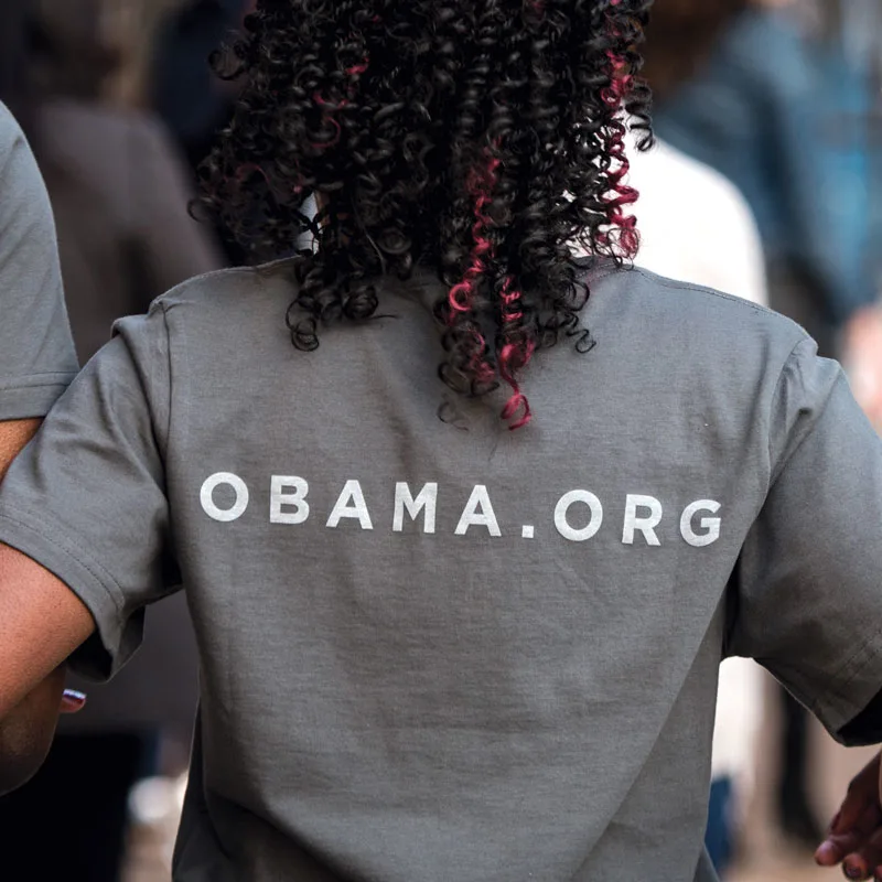The back of a woman wearing a t-shirt that reads obama.org.