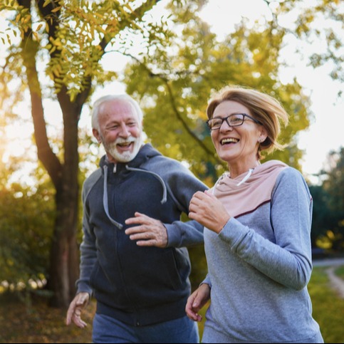Cheerful active senior couple jogging