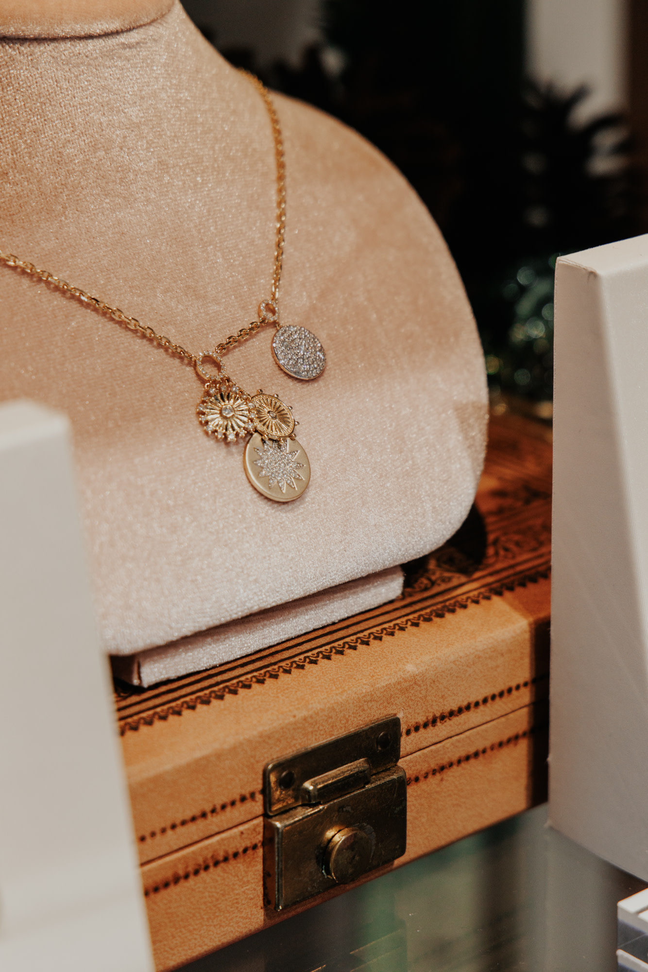 Gold chain with multiple gold charms on it.