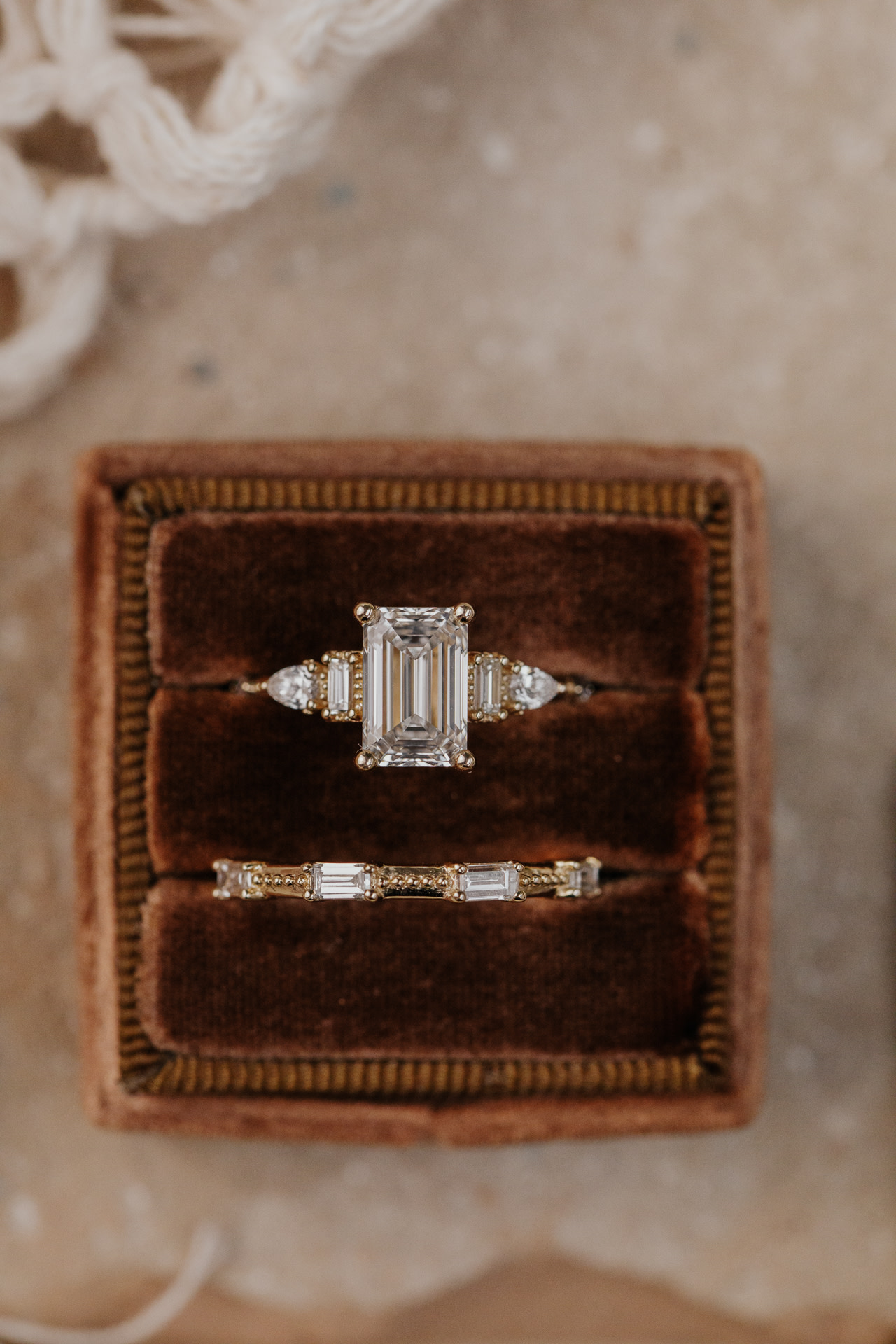 The Encanto emerald cut diamond engagement ring with the Encanto diamond wedding band in a brown velvet box.