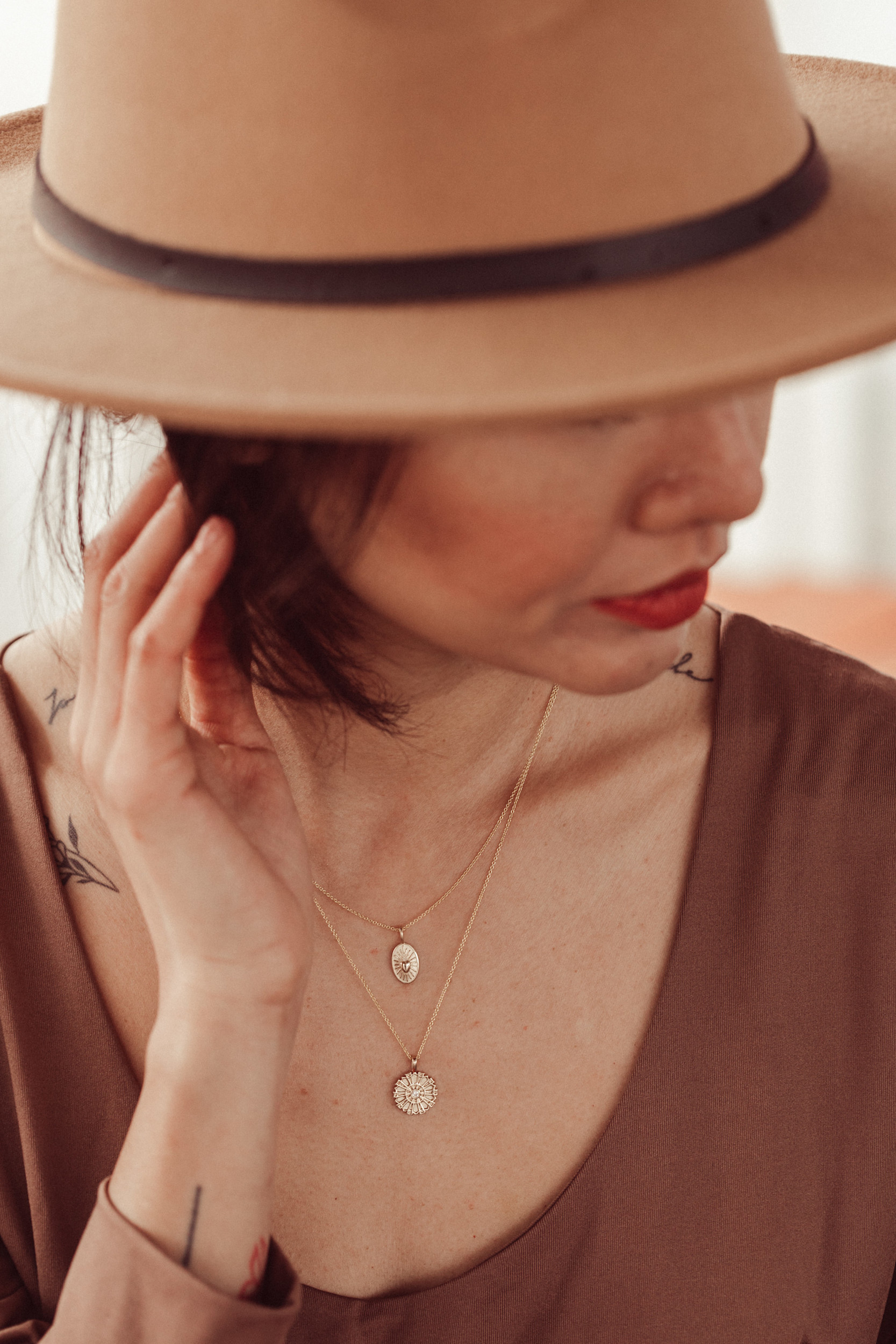 Women wearing multiple gold charm necklaces.