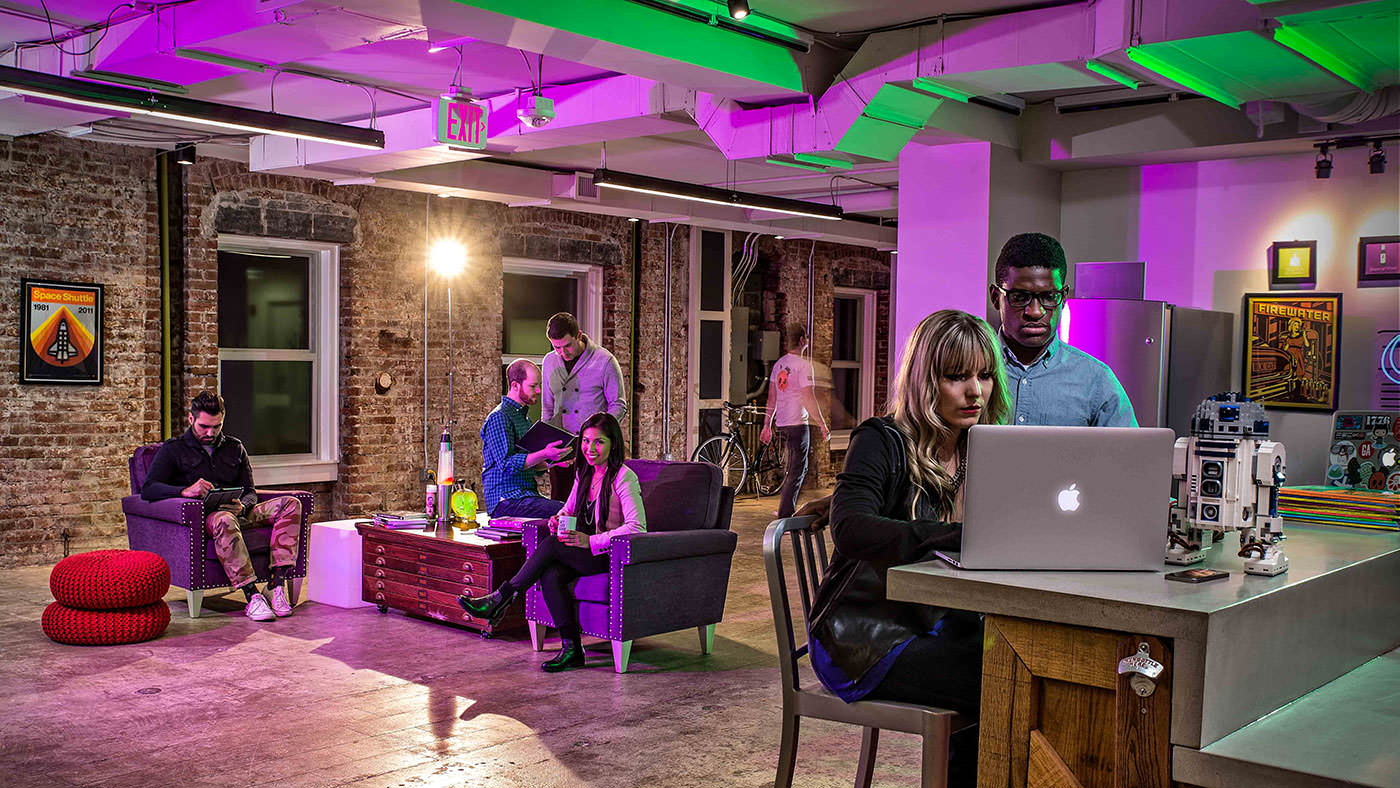 A photo of the nclud team in the office, with dramatic green and purple lighting mirroring the rebrand