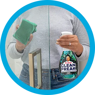 A person cleaning soup scum of shower glass with CleanFreak Unstopables