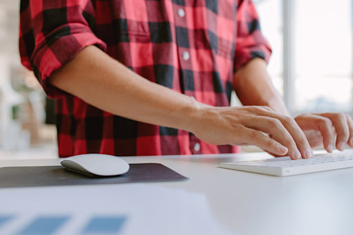 Young man standing at his desk in a modern office environment