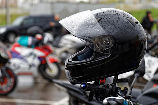 Wet motorbike helmet on handlebars