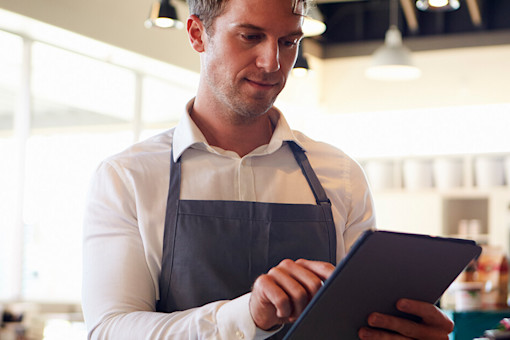 Cafe employee checking his tablet