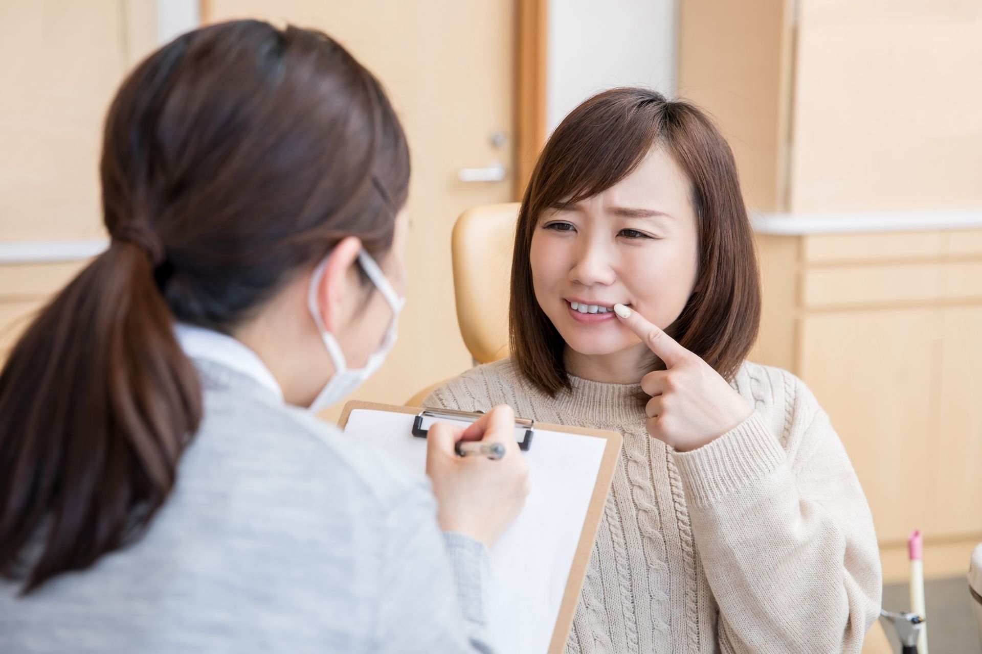 歯科医院で悩みを相談する女性
