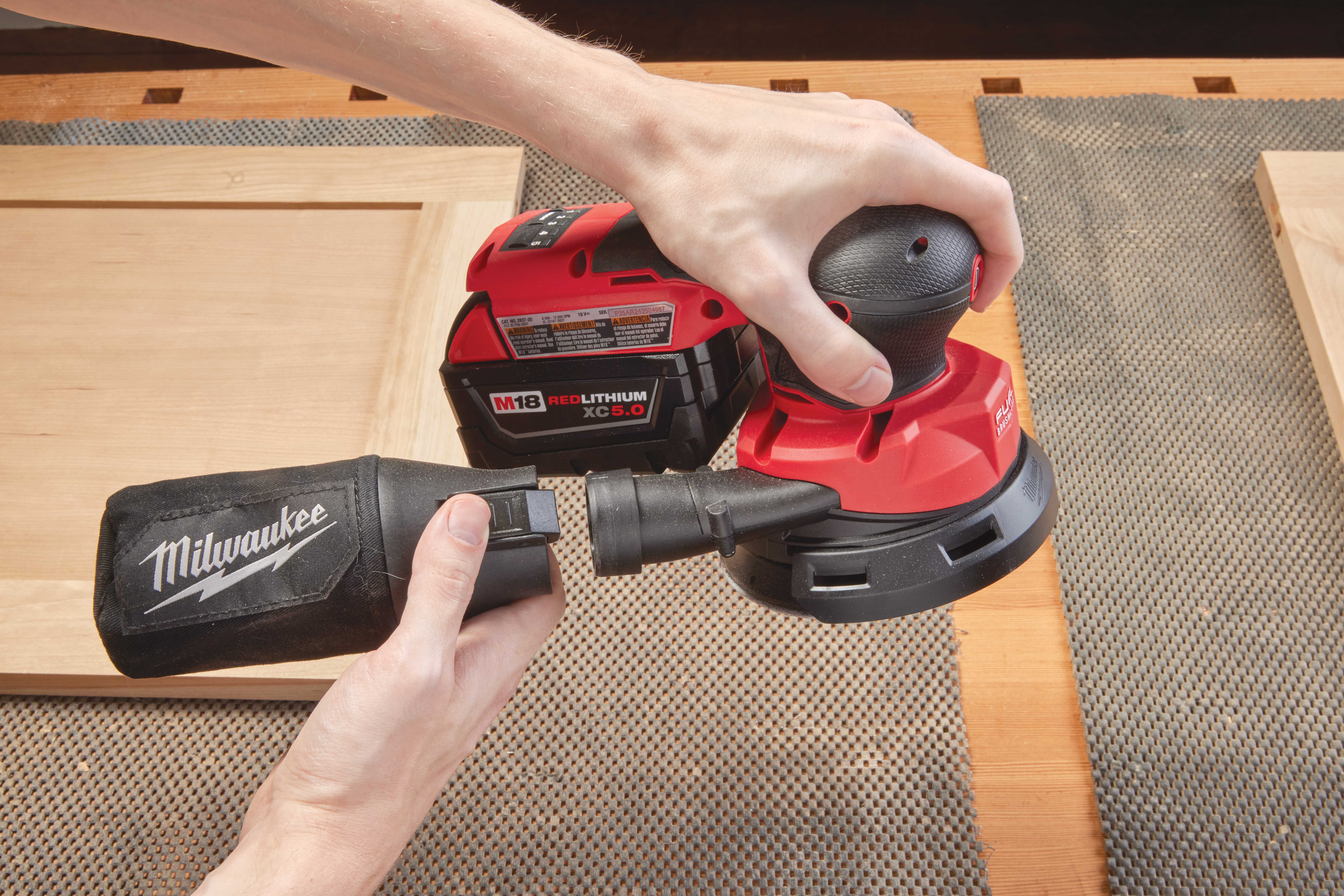 The M18 RANDOM ORBIT SANDER's quick-release lever for the bag and hose conduit