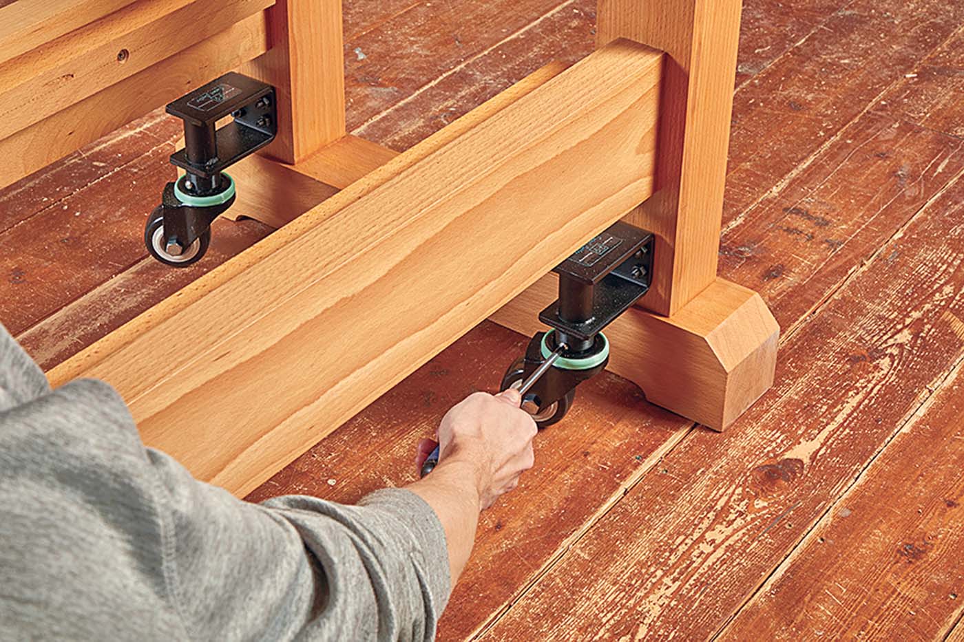 Screwing in wheels onto work bench