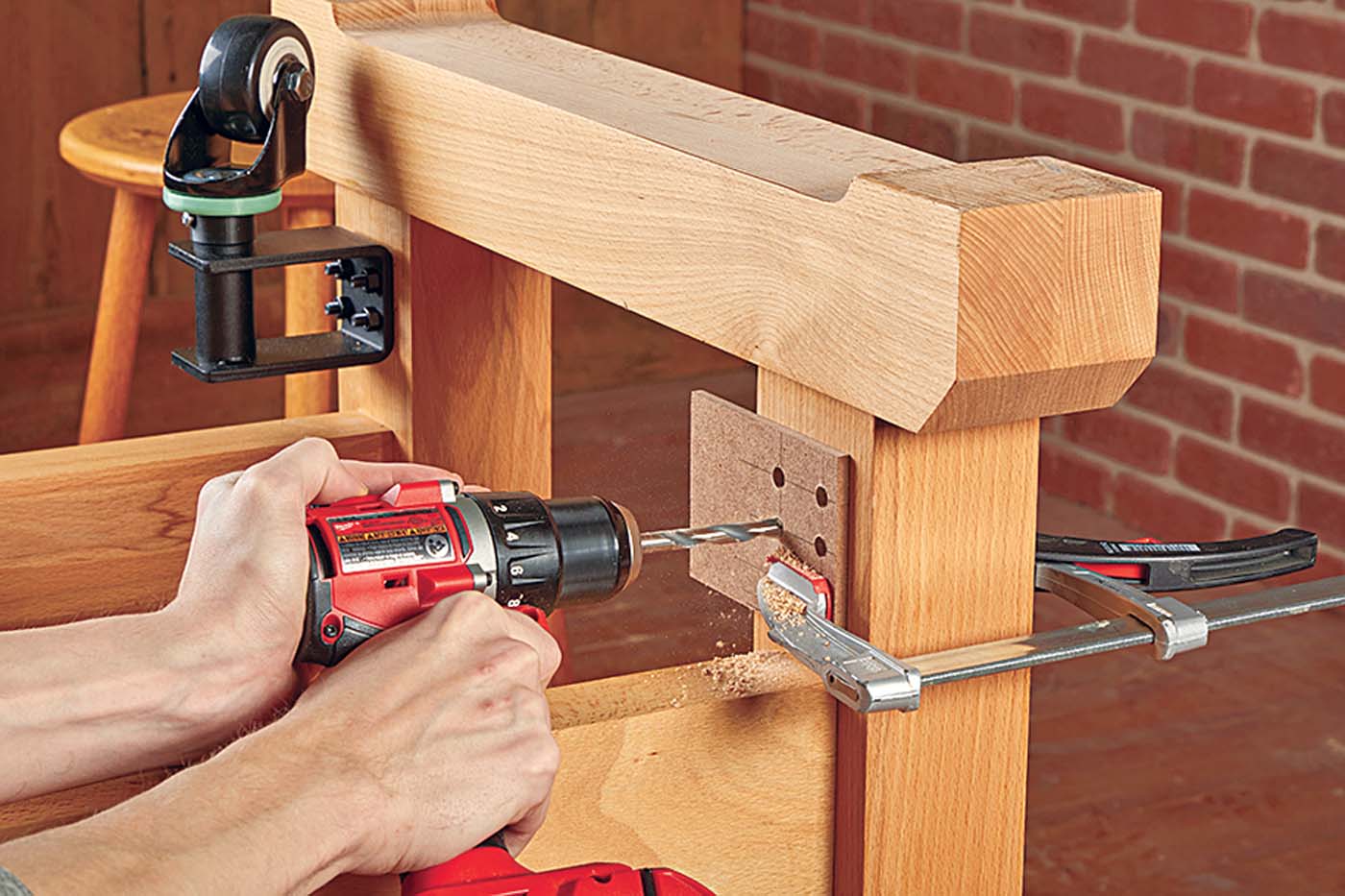using hardboard template and clamp to drill into work bench leg