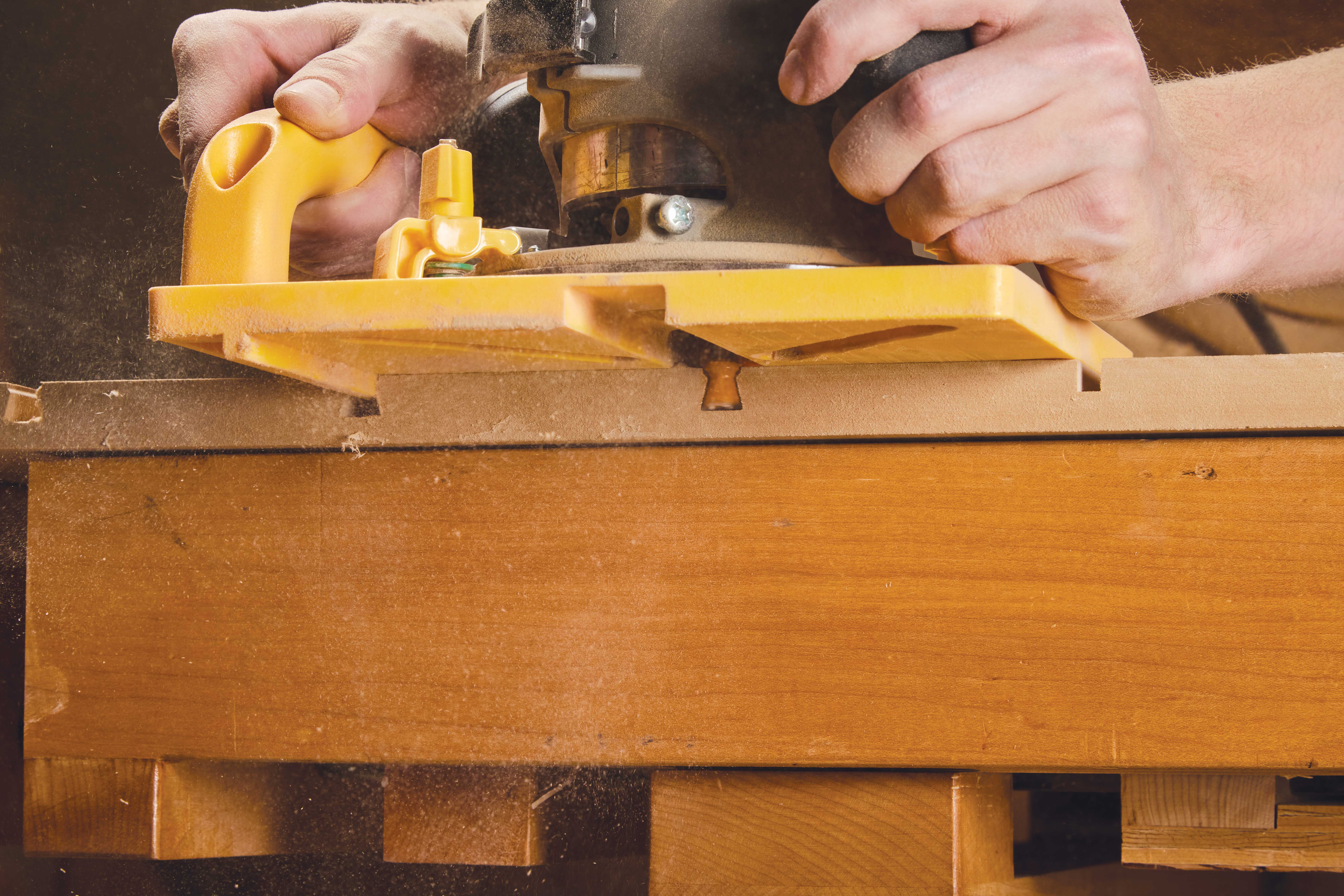 Image shows router using dovetail bit to create dovetail track