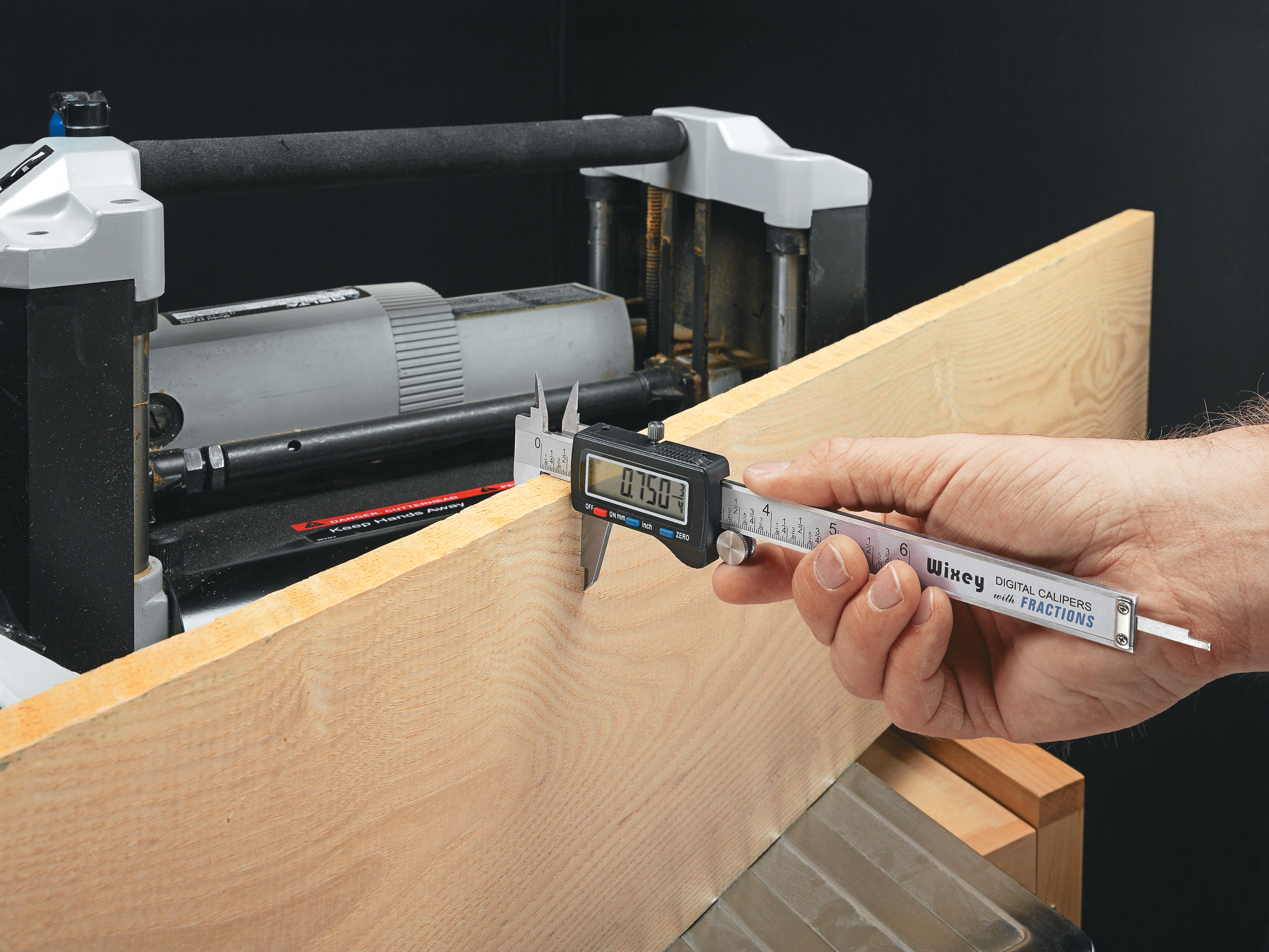 caliper measuring wood board