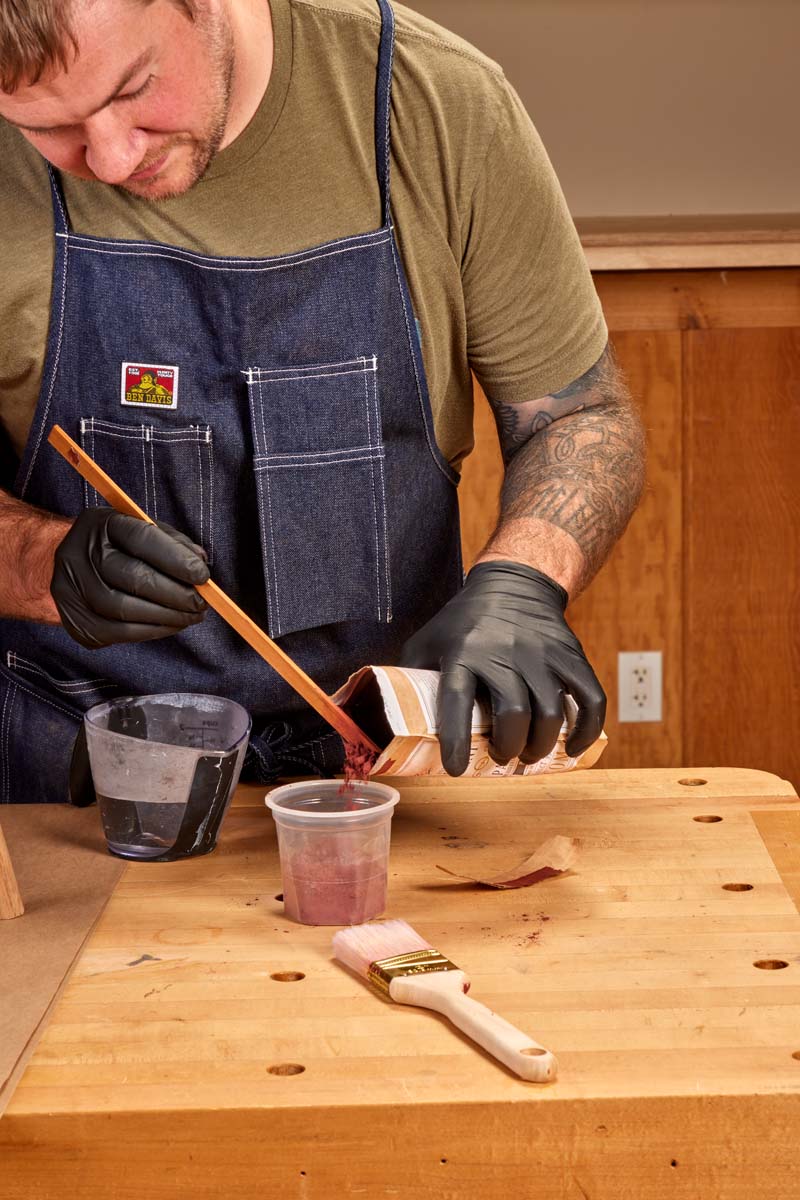 pouring powdered red milk paint in plastic cup
