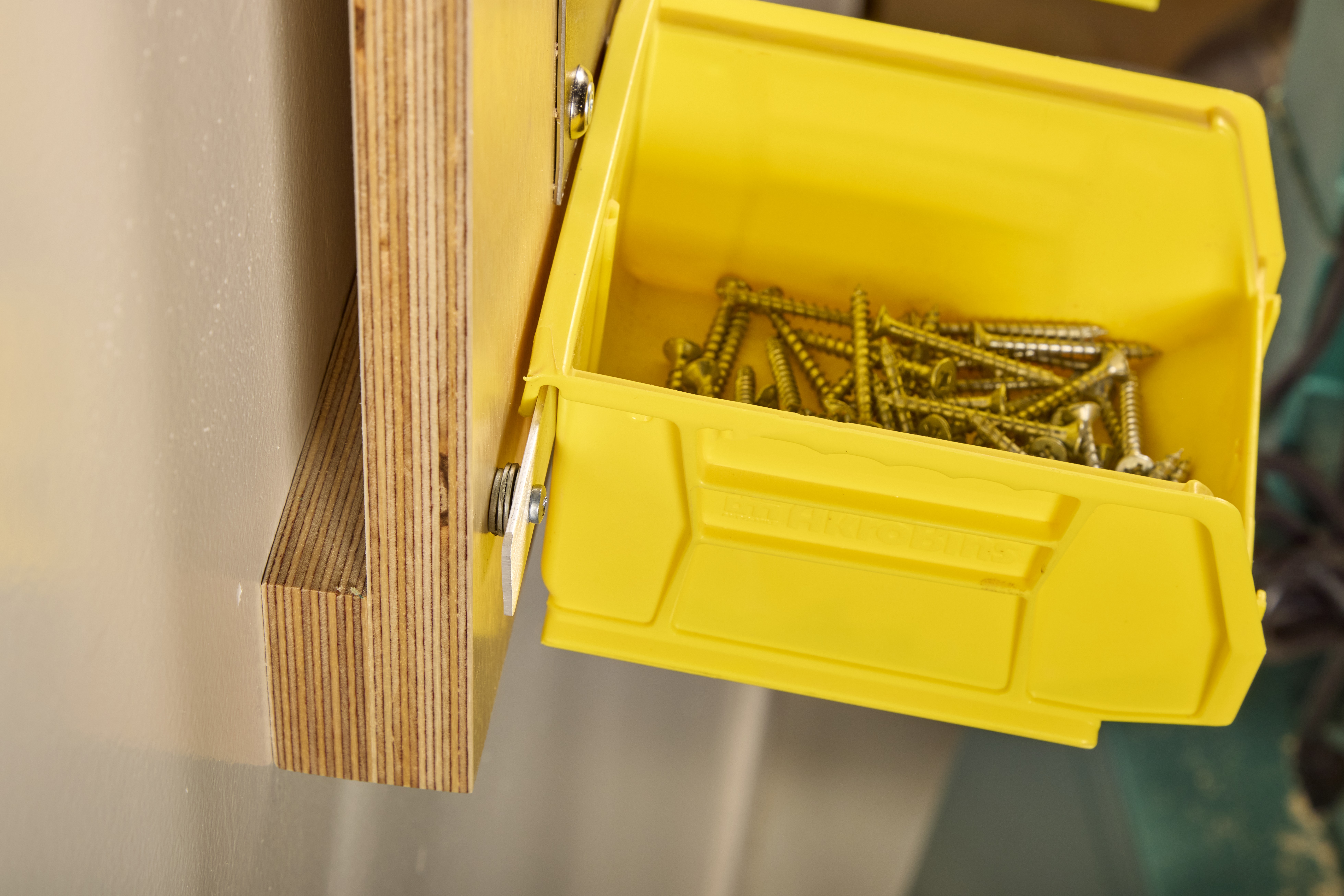 close up of washer and screws holding up yellow bins