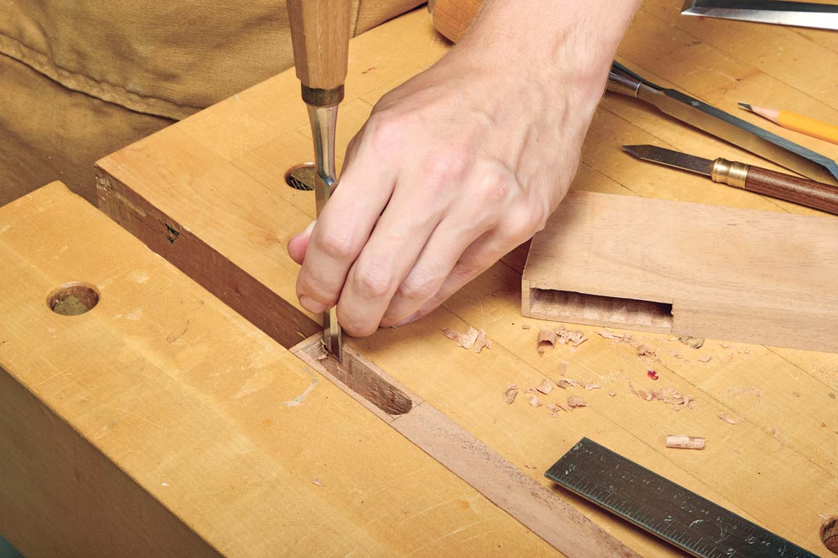 using chisel to clean out mortise by chopping with the grain