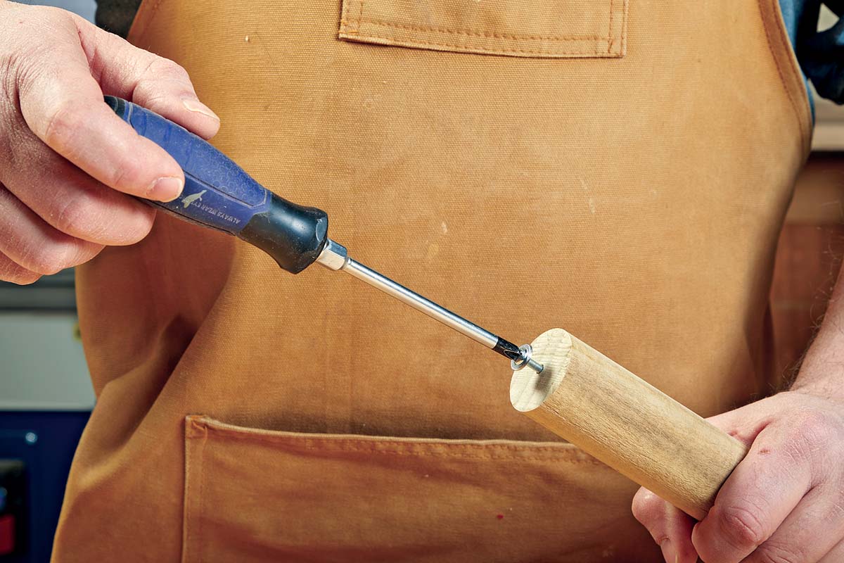 using screw driver to screw in pan head screw into dowel