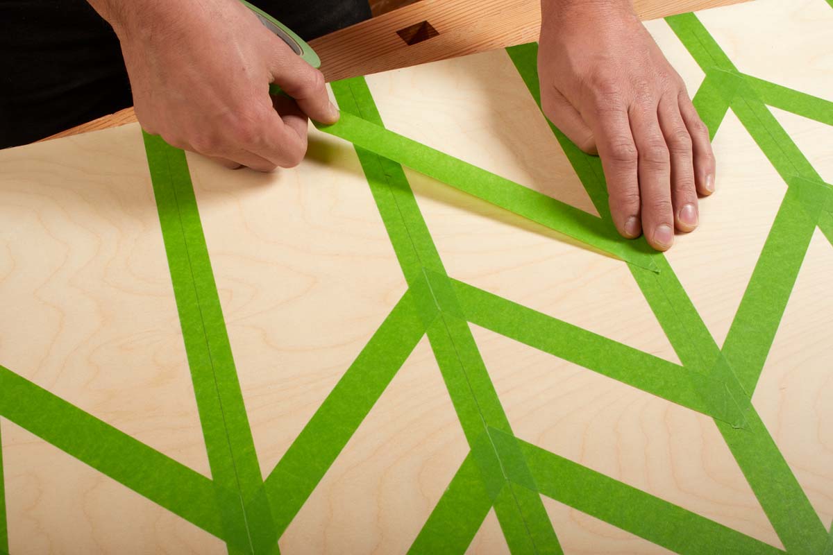 applying green painters tape according to the zig zag pattern and pressing down on it