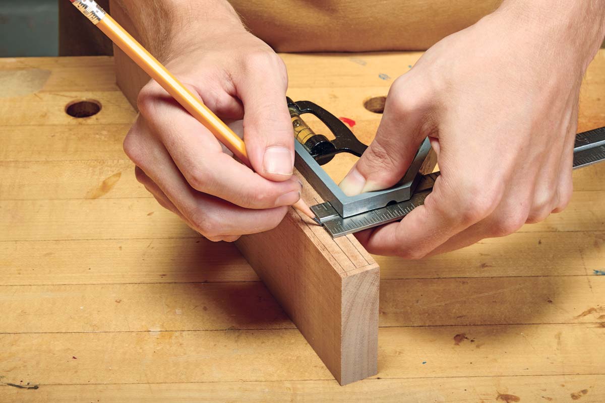 using corner level and ruler to mark centerline for mortise with pencil