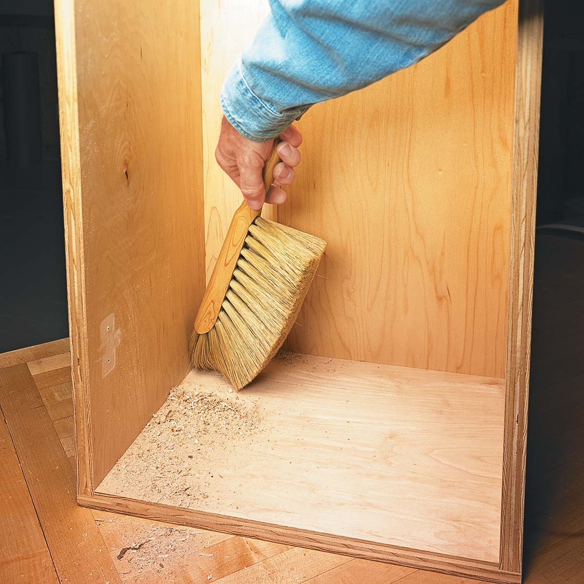 using flare-tip bench brush gets into tight corners to remove sawdust from shop corners