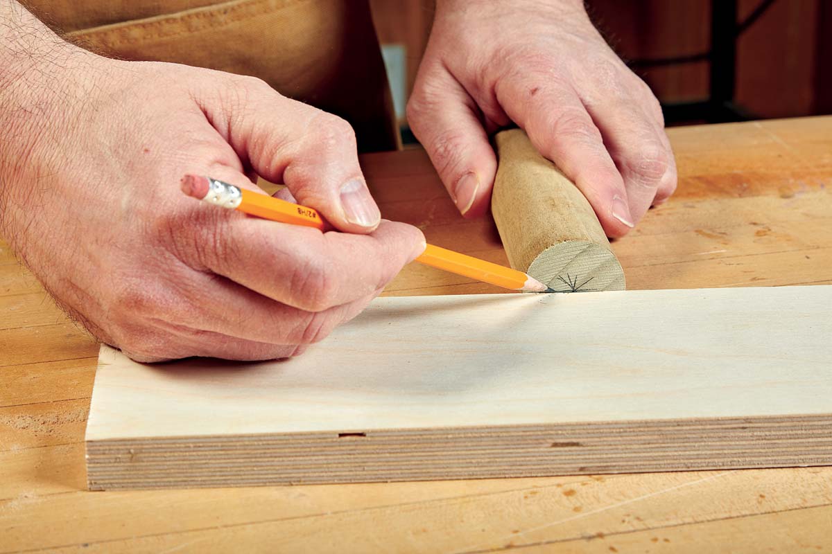 makring end of dowel with pencil and wood used as straight edge