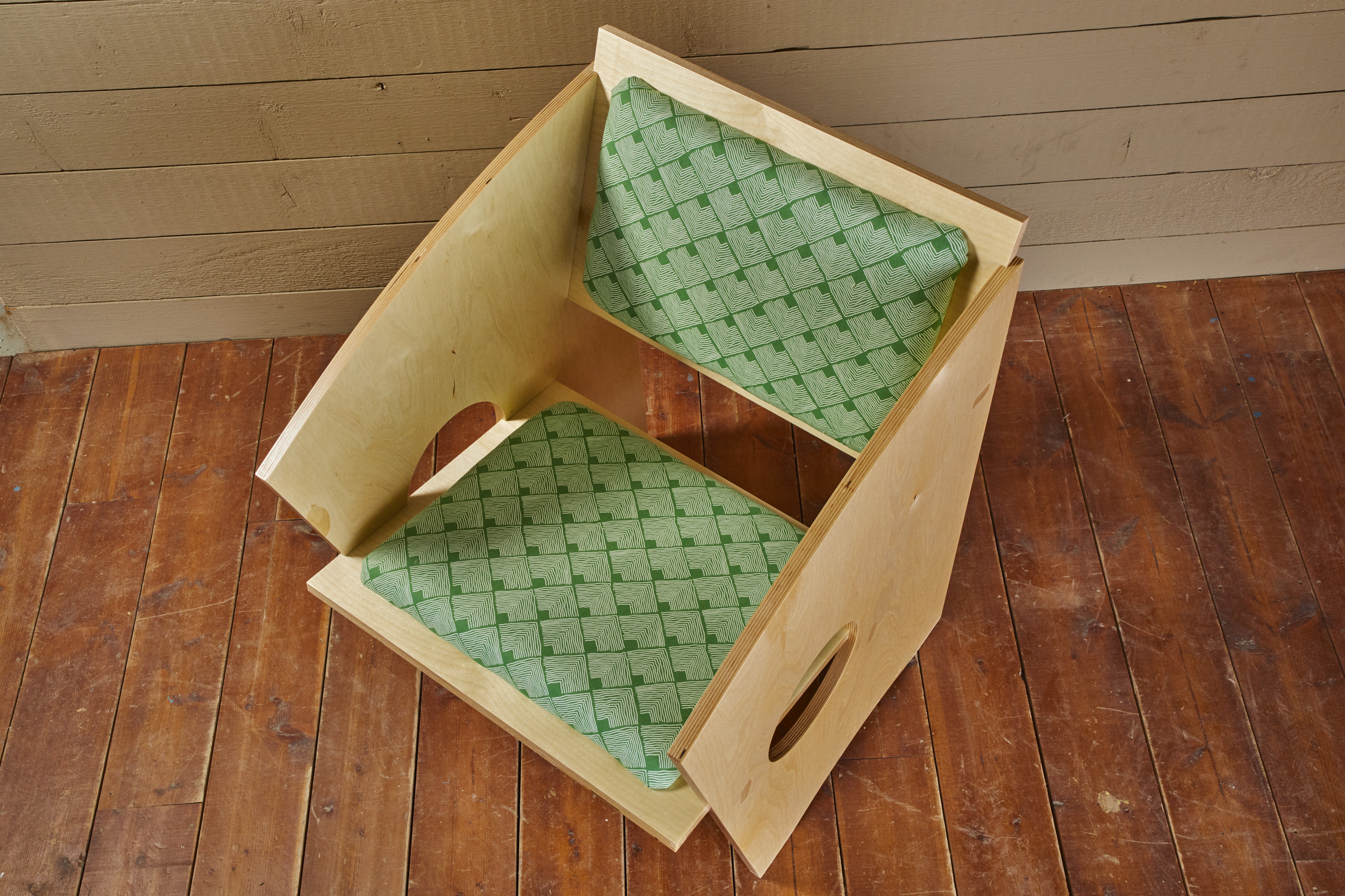 green cushioned wood chair made with plywood sides