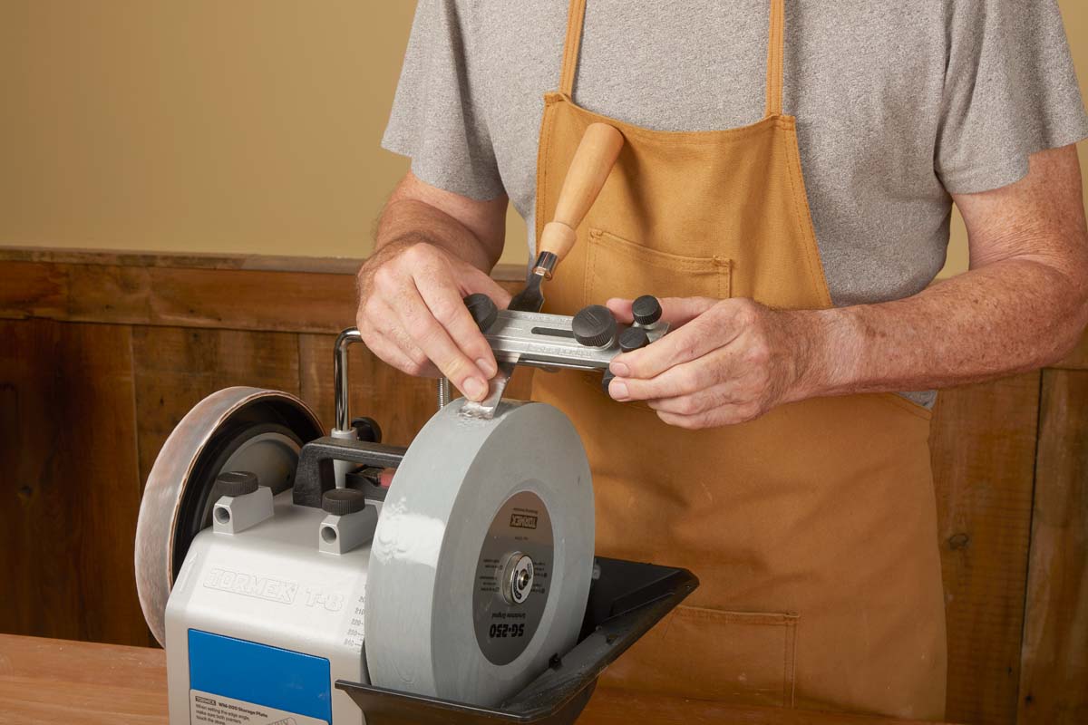 flat blade jig being used to hold in place skew chisel on water sharpening wheel