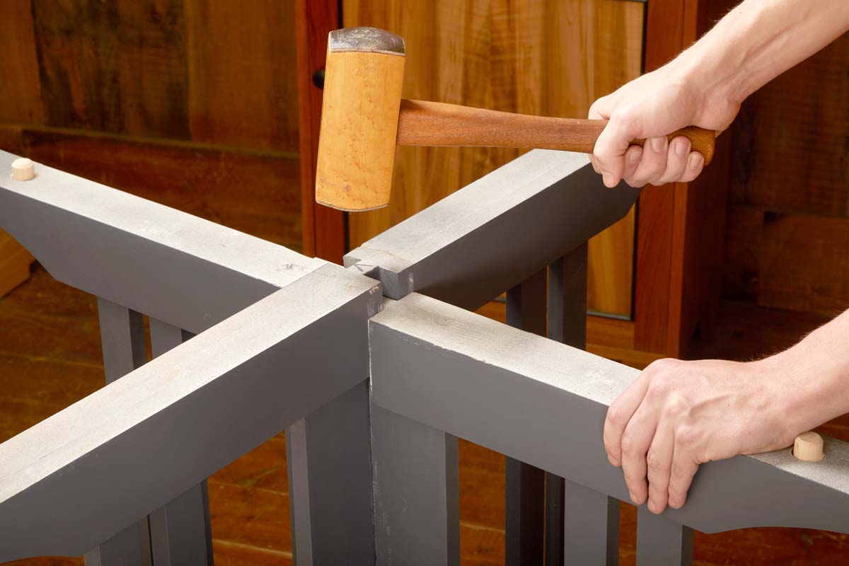 deadblow mallet hammering down on grey parts being joined together