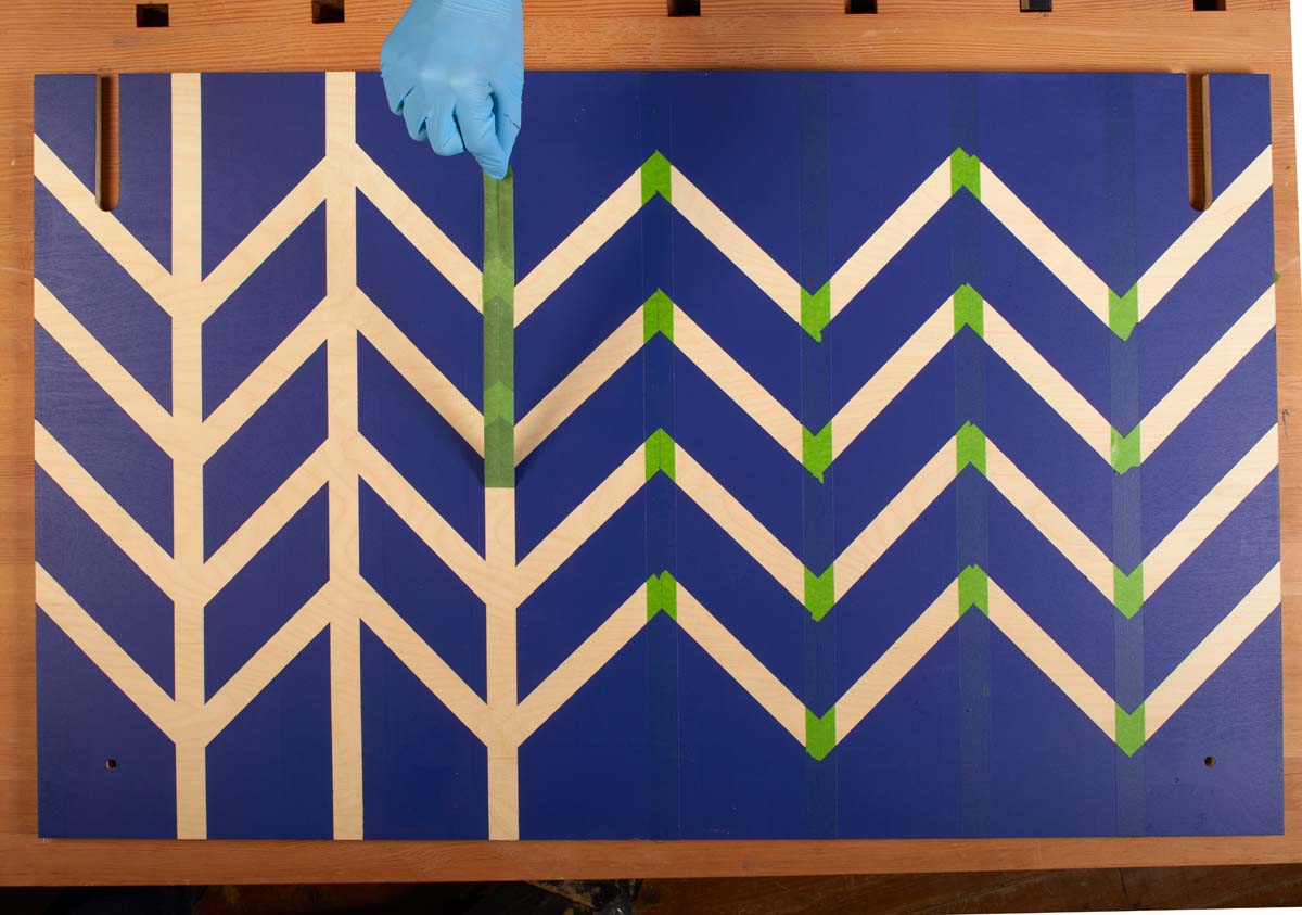 slowing peeling off tape after dark blue paint has dried