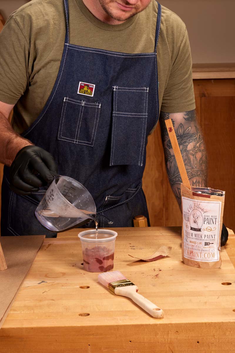 pouring hot water in plastic cup with powdered red milk paint for 1:1 ratio volume