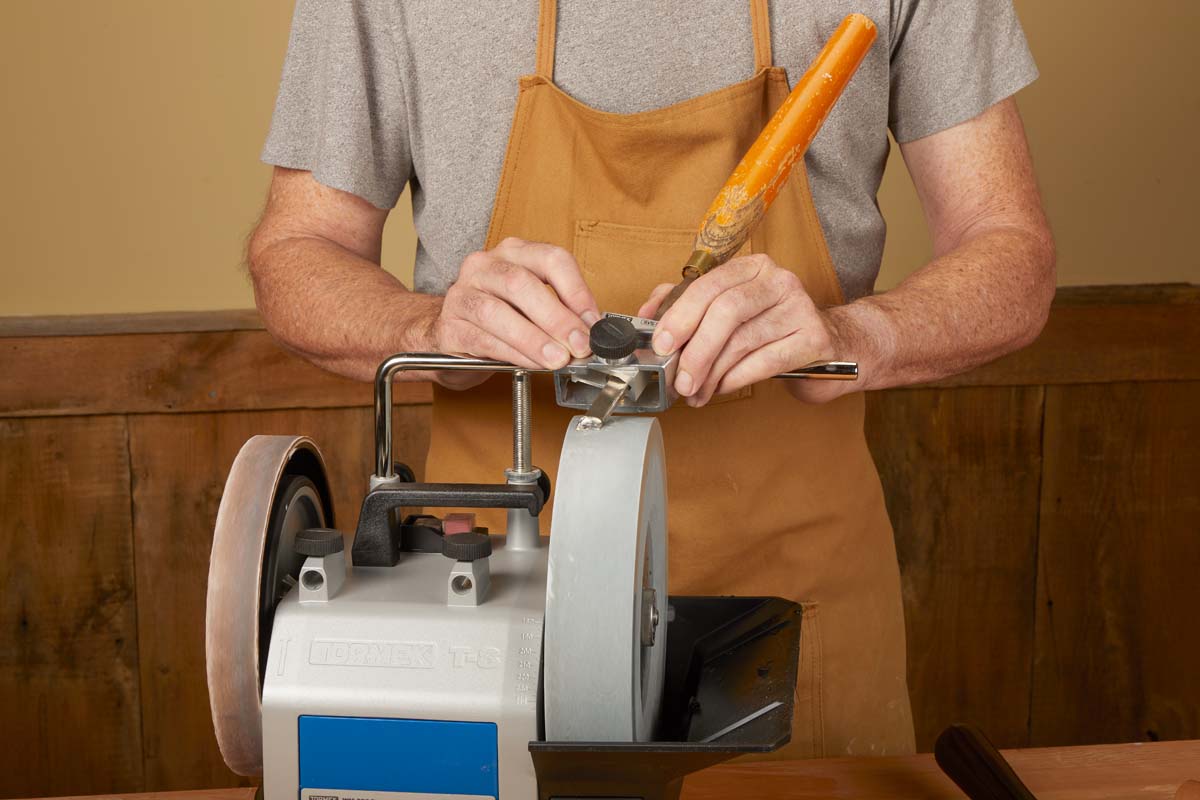 multi jig being used to hold in place skew chisel on water sharpening wheel