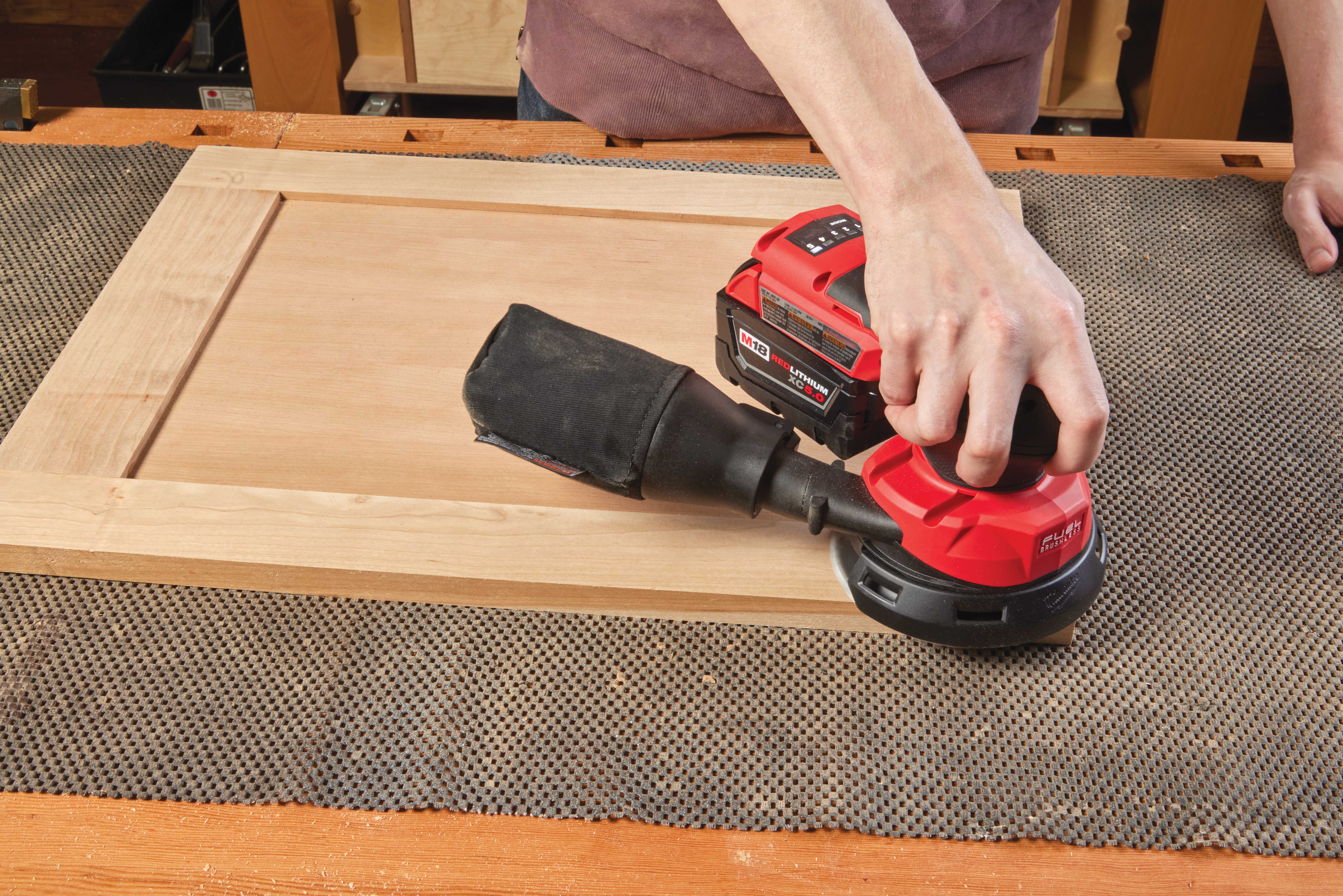 M18 RANDOM ORBIT SANDER being used to sand door