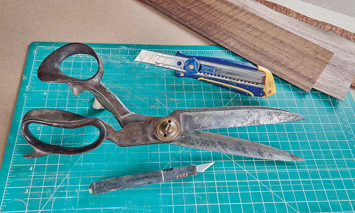 scissors, box cutter and craft knife on cutting matt