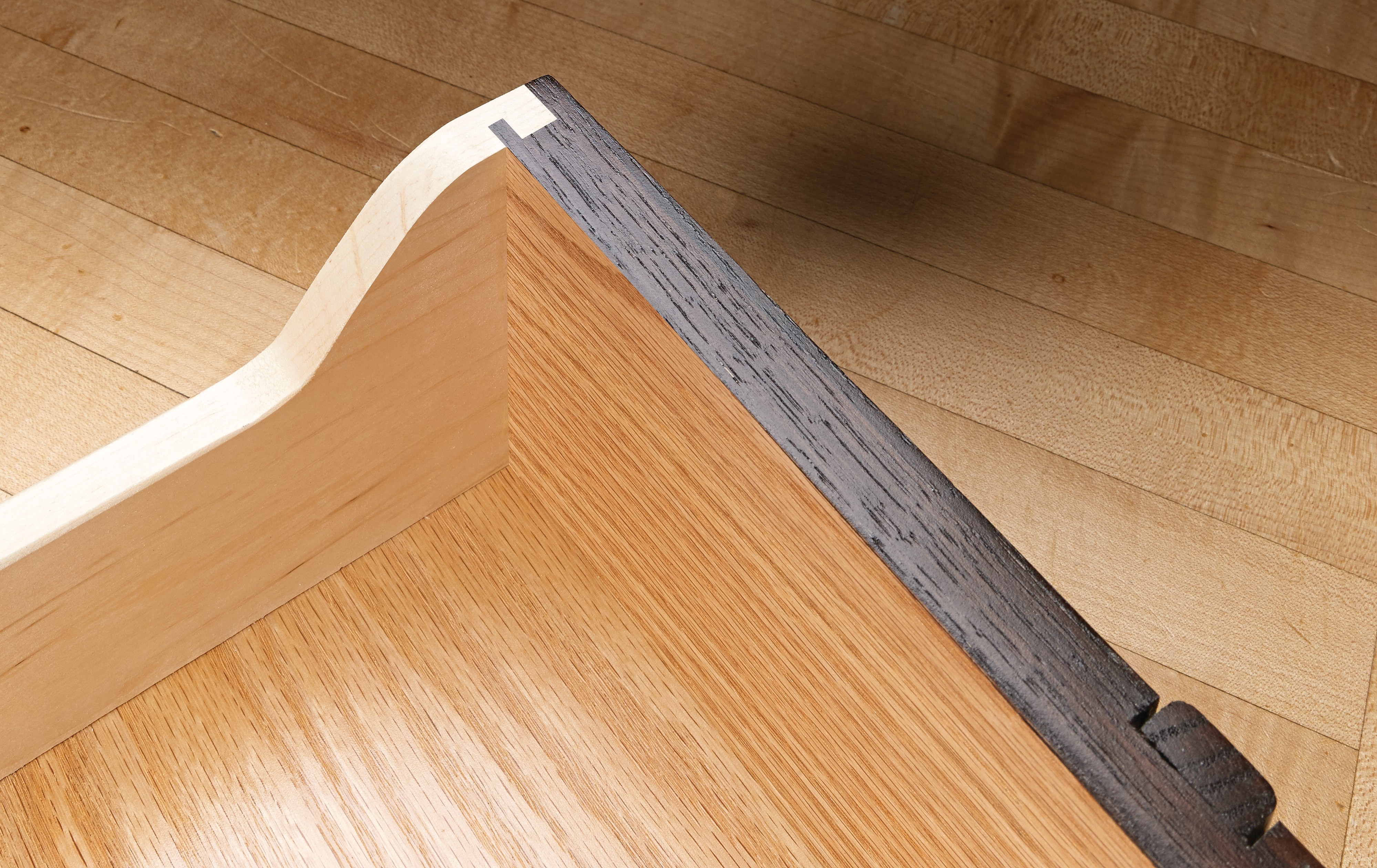 reverse angle of inerlocking rabbet jointed drawer with dark stained front and light sides