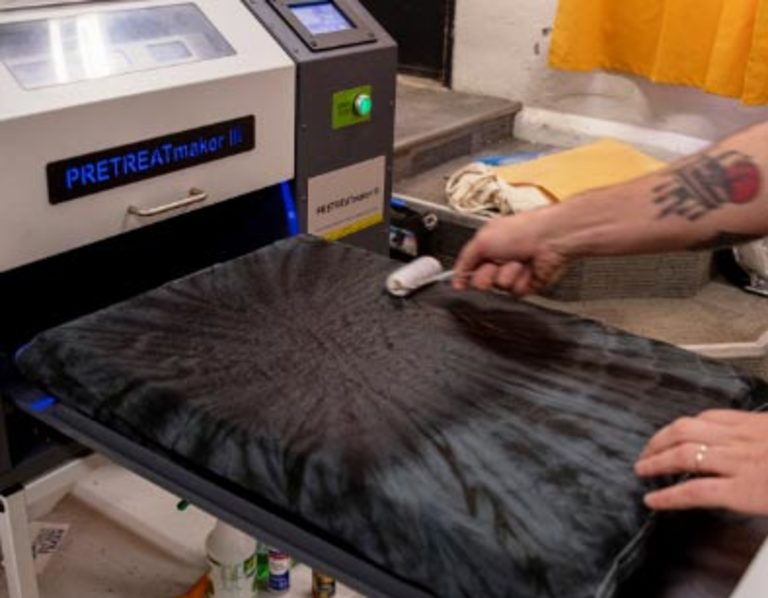 Person applying liquid pre-treatment to a t-shirt