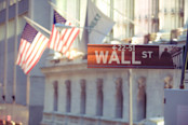 Wall Street sign with American flag in the background