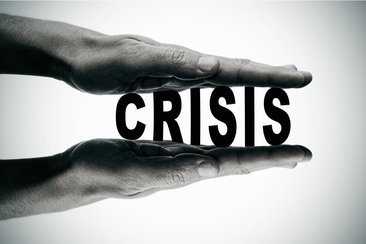 Man hands pressing the word crisis
