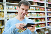 Man with dollars and calculator considers costs in the store