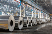 Row of rolls of aluminum lie in production shop of plant