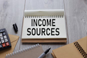Income sources wooden table with notepad