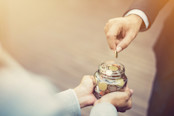 putting money in glass jar