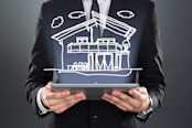 Man holding a tablet with an image of a house reflecting off