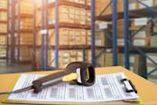 Barcode scanner in front of modern warehouse