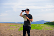 Man searching through binoculars