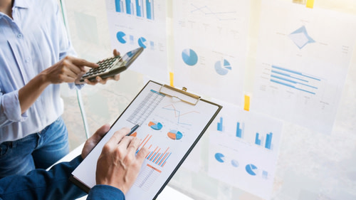 Two individuals studying business documents.