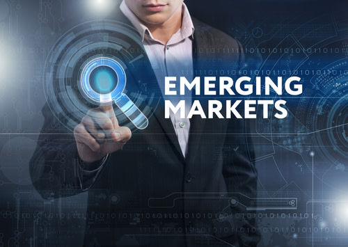 Business man behind text that reads "Emerging Markets"